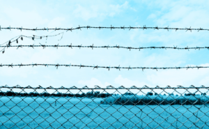 Blue Sky with barbed wire in the foreground | Hero Image for The Complete Guide to Post-Incarceration Syndrome