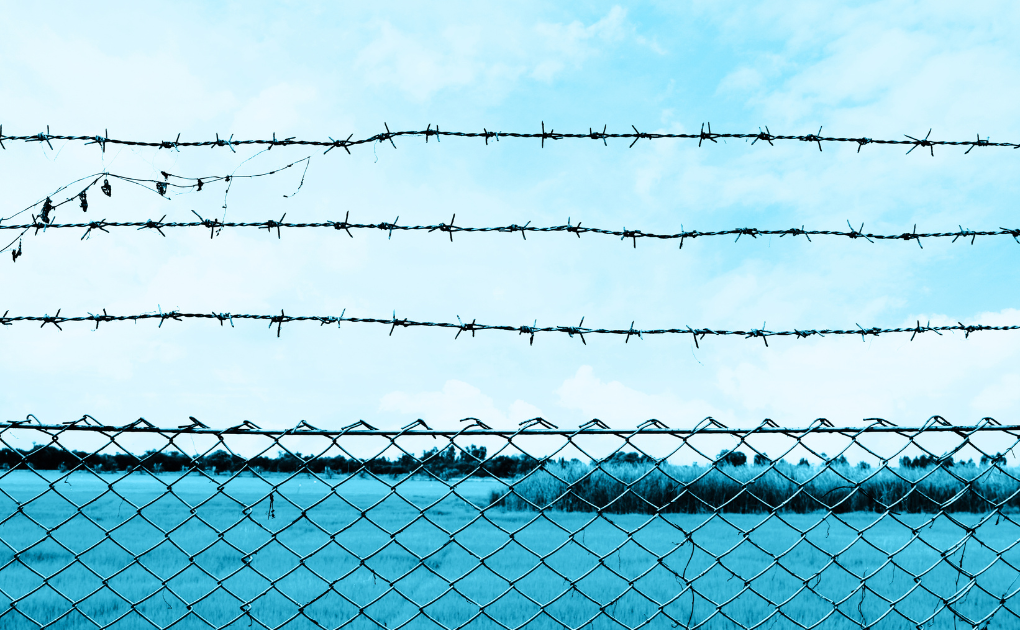 Blue Sky with barbed wire in the foreground | Hero Image for The Complete Guide to Post-Incarceration Syndrome