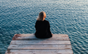 woman sitting on a pier \ image for setting intentions for the new year