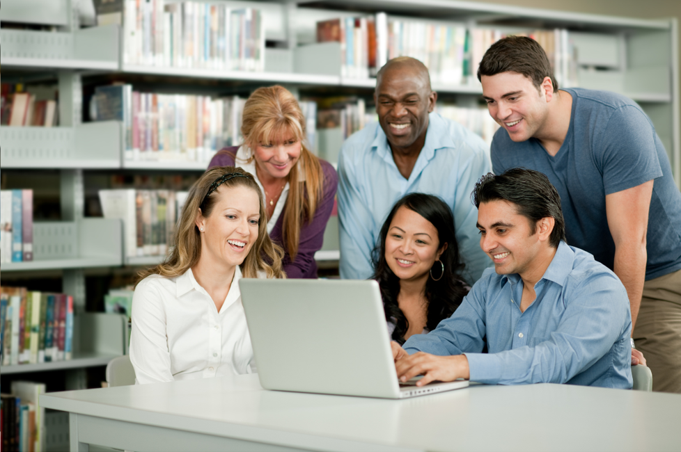 Group of people around a computer smiling | Featured Image for white-labeled motivational interviewing training