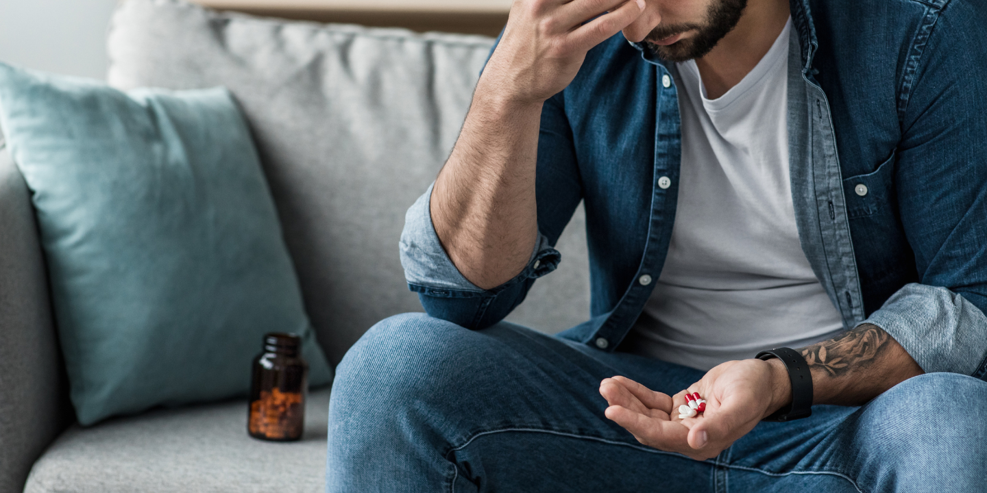 Change the narrative on substance use disorder hero image featuring a white man with red pills in his hand.