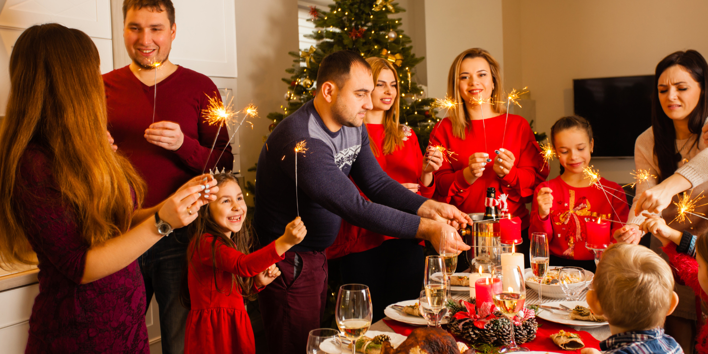 hero image for how to love someone with substance use disorder | a family is gathered around a table lighting sparklers