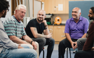 Group of mulit-racial men in a support group | hero image for peer recovery specialist post